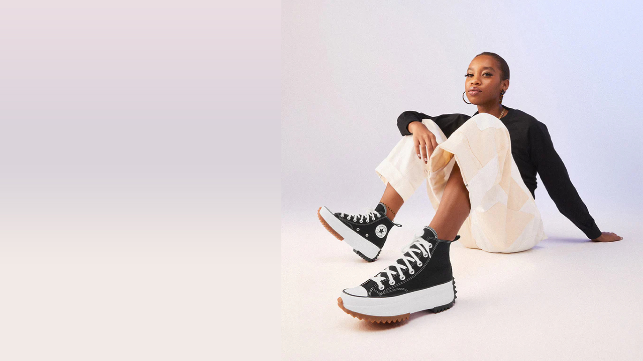 Femme en tenue monochrome portant des baskets dans un studio lumineux